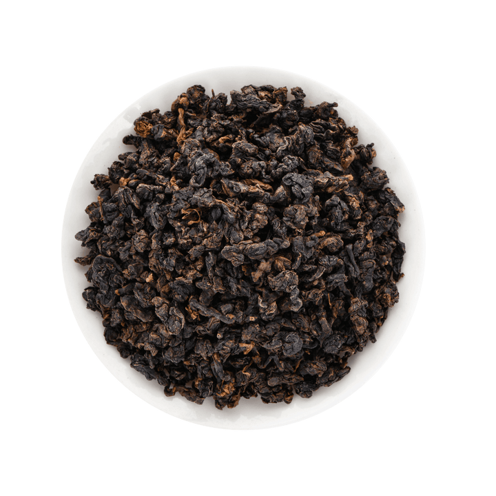 Dark brown Oolong tea leaves in a white bowl