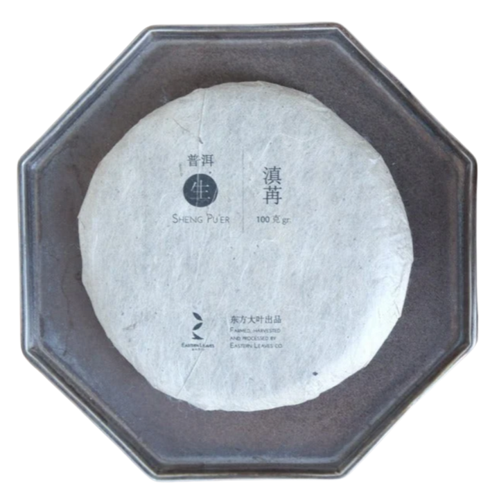 White round tea cake with text on a gray octagonal plate