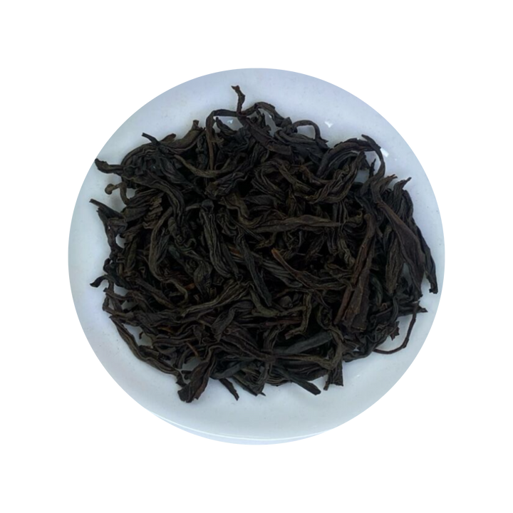 Dark curled Ceylon Black Tea leaves in a white bowl
