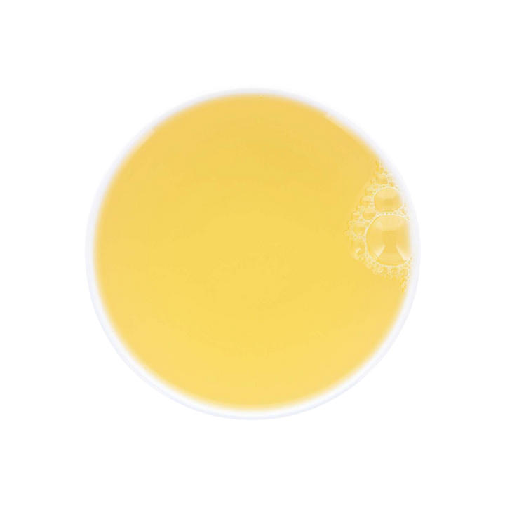 Yellow Mao Feng Green tea soup in a white cup