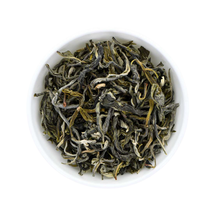 Dry Chinese Mao Feng green tea leaves in a white bowl