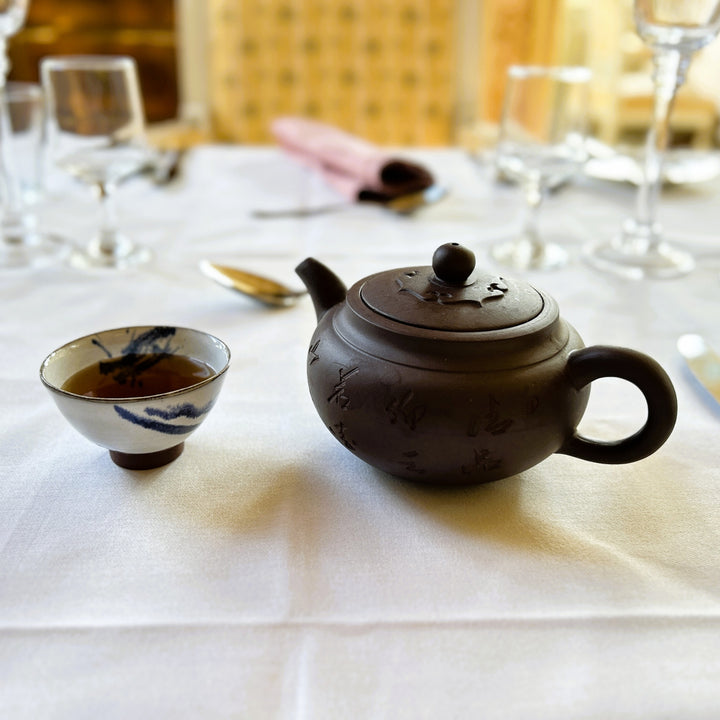 Tea set with Chinese Yixing teapot and cup on a tablecloth