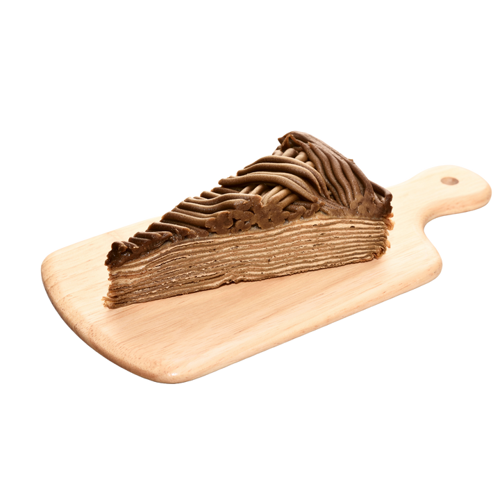 A slice of Hojicha mille crème cake with piped chocolate frosting on top, presented on a light wooden serving board