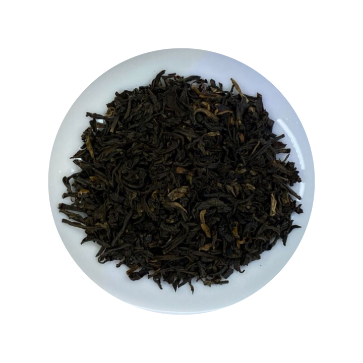 Black Earl Grey tea leaves in a white bowl