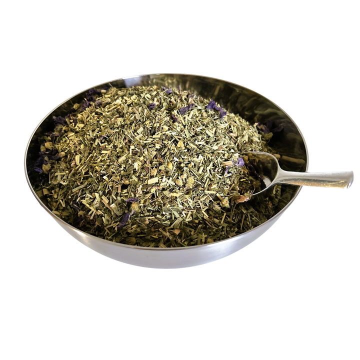 Big metal bowl full of dried herbals and flowers with a metal spoon