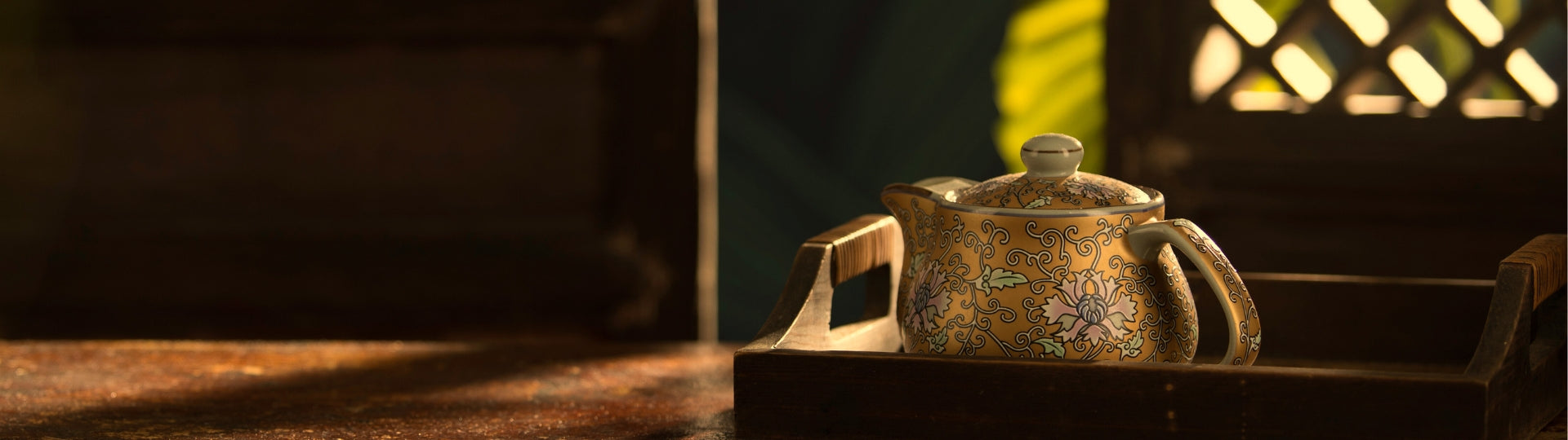 Decorative golden teapot with intricate designs on a wooden surface
