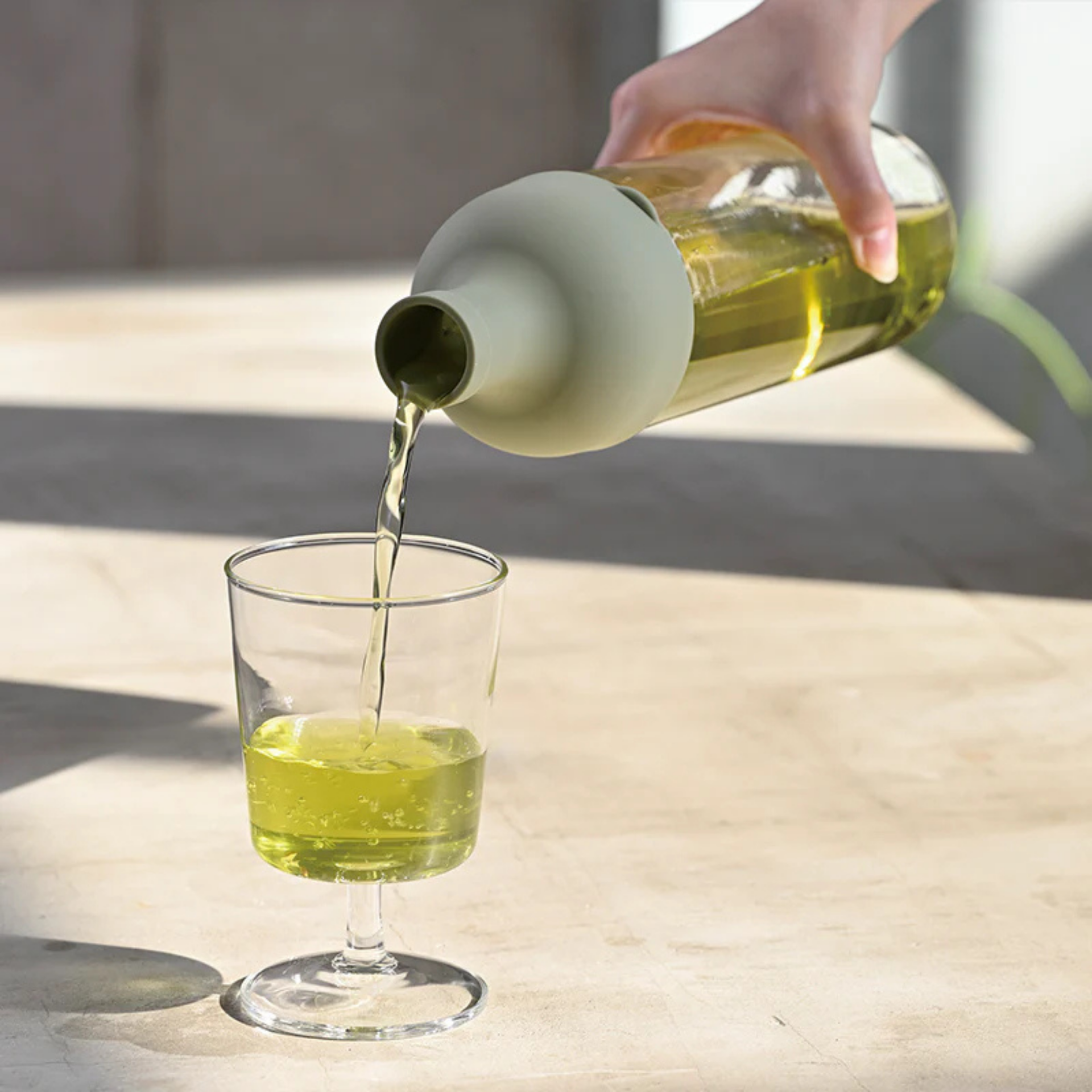 Green cold brew glass bottle pouring tea into a glass