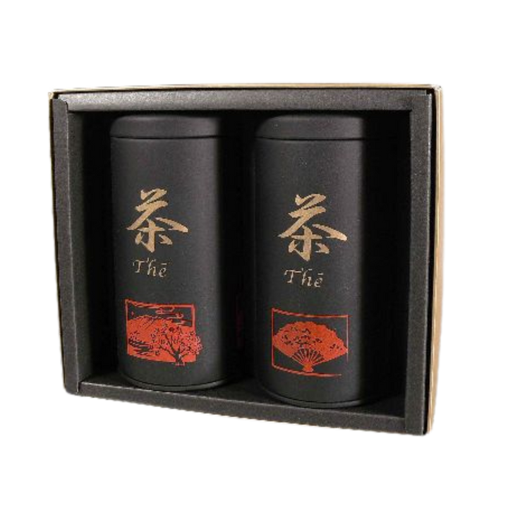 Two black tea canisters with red and gold designs in a box