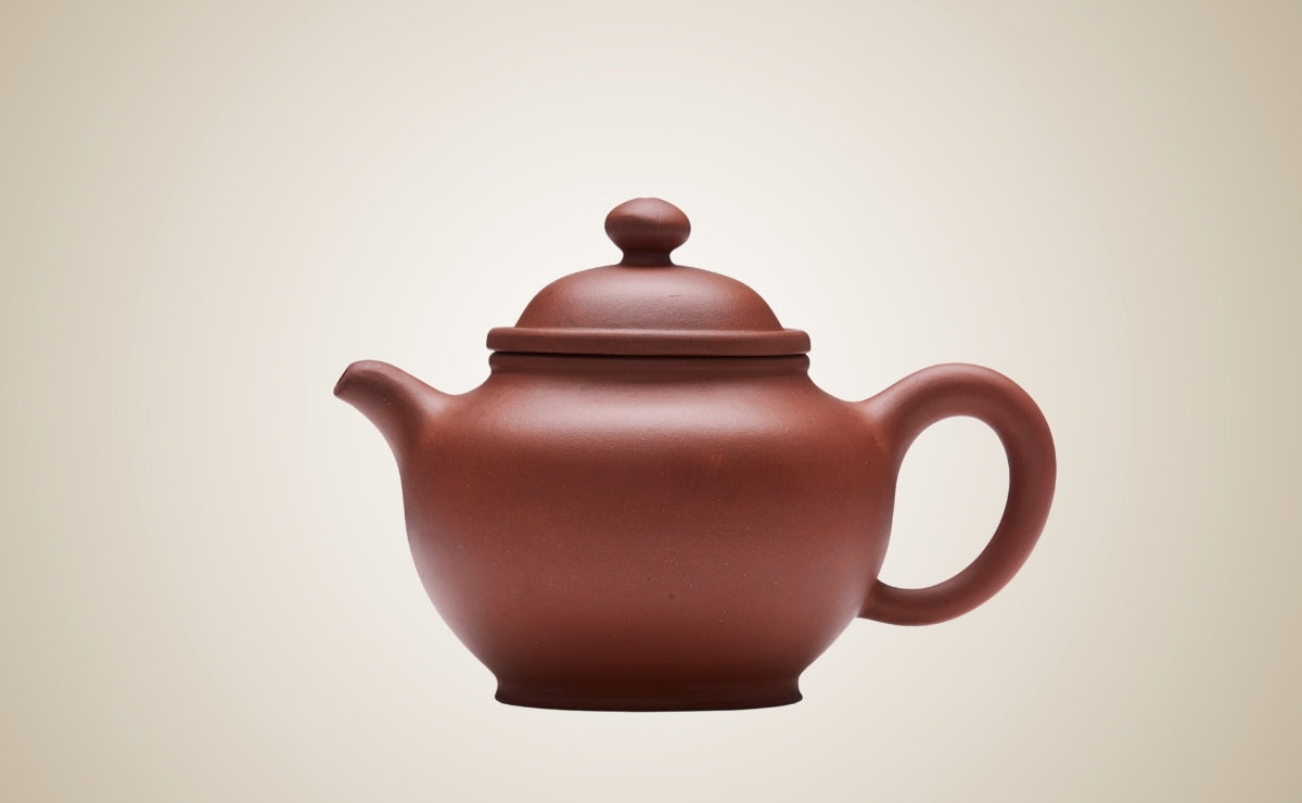 Red clay Yixing teapot on a beige background