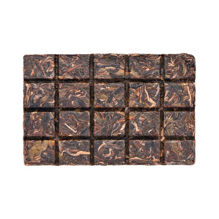 Compressed square tea cake with dark-brown and lighter brown tea leaves divided in small break-off squares