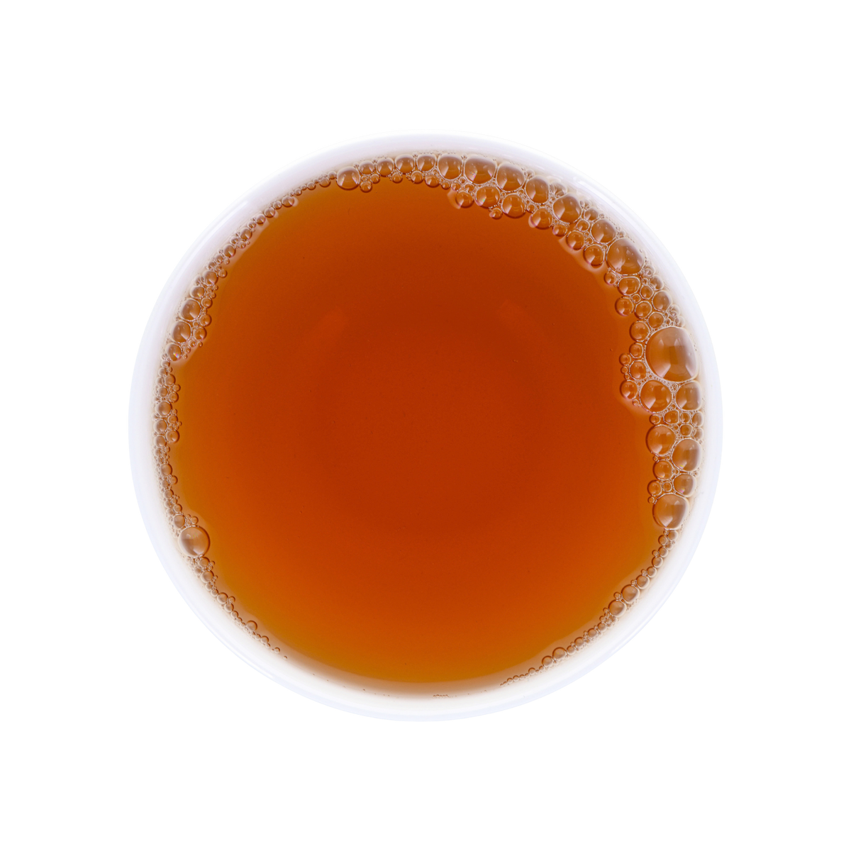 A top-down view of a white cup filled with amber-brown tea, showing a layer of bubbles around the rim