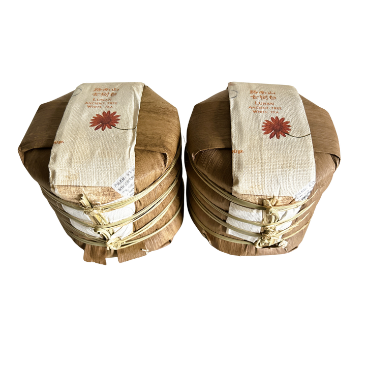 Two wooden baskets made of banana leaves holding each 5 white tea cakes